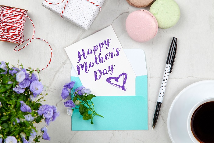 a cluttered desk with a happy mother's day card